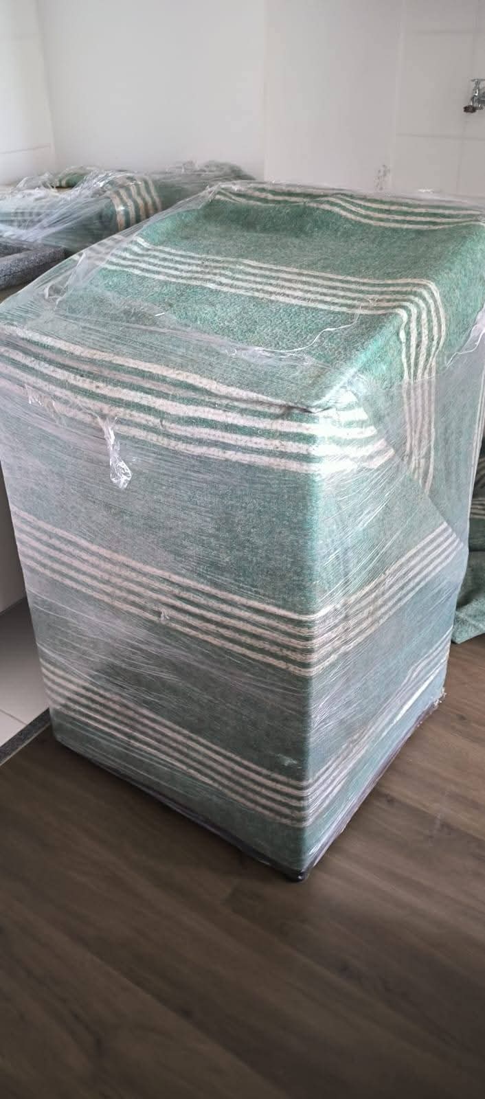 Frete, Mudança e Transportadora em Balneário Camboriú – SC 5 Máquina de lavar protegida com cobertor de mudança e plástico filme para o transporte